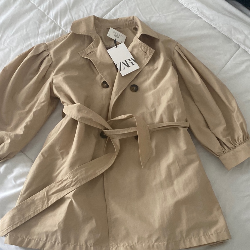 Girls size 8 trench coat with trendy puffy sleeves and plaid interior.